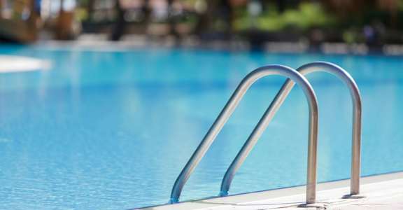 a swimming pool with stainless steel ladder