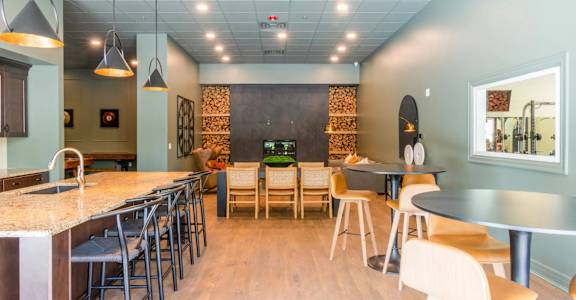 a dining room with tables and chairs and a bar with stools
