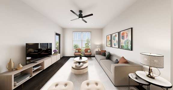 A modern living room with a large sofa, a coffee table, and a ceiling fan.