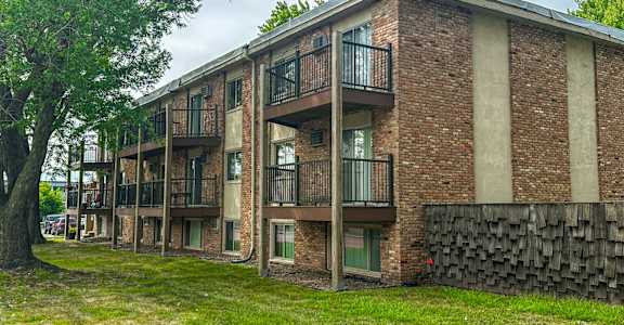 A brick building with a balcony on the second floor.