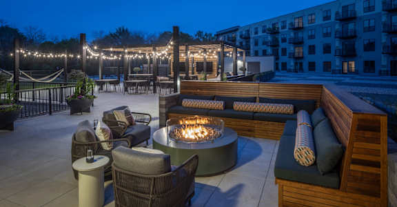 A patio with a fire pit and seating area.
