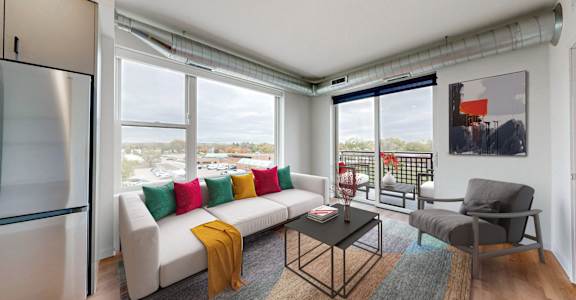an open living room with a white couch and a table with colorful pillows
