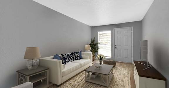 A living room with a white couch, a small table, and a lamp at 46Eleven Apartments, Dallas, TX, 75228