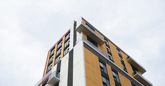 A tall building with a yellow and white facade.