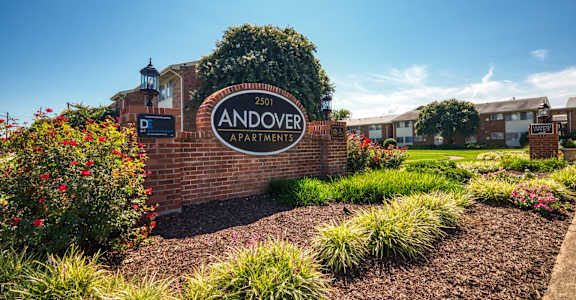 the sign apartments in front of a brick wall
