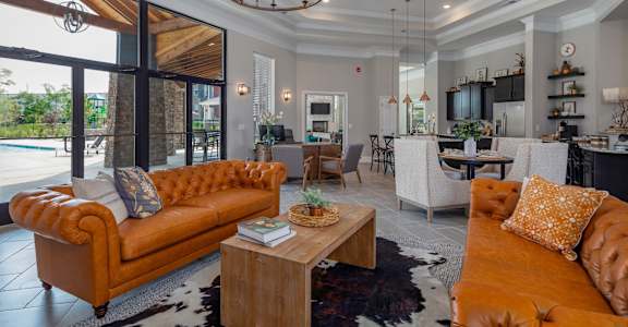 A living room with a large orange sofa and a wooden coffee table.