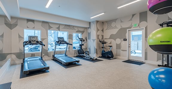 A gym with treadmills, exercise bikes, and a balloon at Falls Creek Apartments in Coeur d'Alene, Idaho, 83815