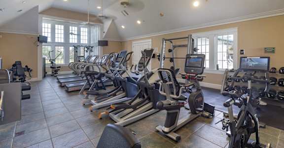 A gym with treadmills, exercise bikes, and other equipment.