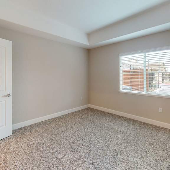 an empty bedroom with a white door and a window at Heritage Landing Apartments, Chico, 95973