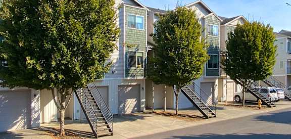 a row of townhomes with trees in front of them