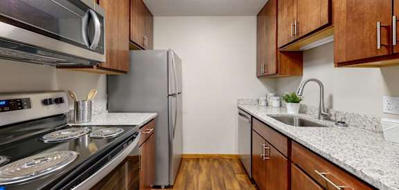 a kitchen with wooden cabinets and stainless steel appliances