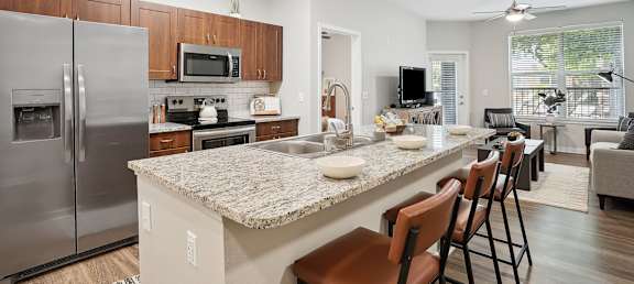 an open kitchen and living room with a granite counter top