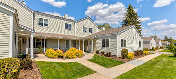 a group of houses with lawns and trees in front of them