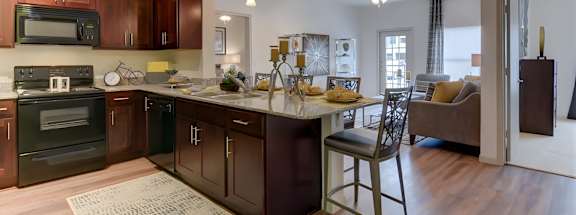 A kitchen with dark wood cabinets and a white island.