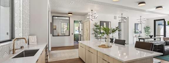 A modern kitchen with a white countertop and wooden cabinets.