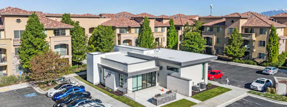 A modern building with a parking lot in front of it.