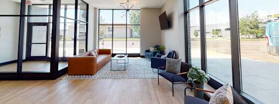 a living room with couches and chairs and large windowsat First Street Lofts in Downtown Bismarck, Bismarck, 58506