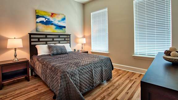 A bedroom with a large bed and a painting on the wall.