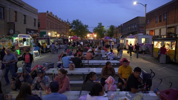 a crowd of people sitting at tables on a street at night  at Antelope Ridge, South Dakota, 57719