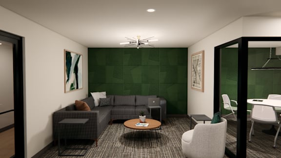 A modern living room with a grey sofa, a coffee table, and a green accent wall.