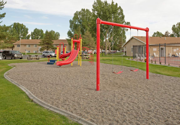 a playground with a swing set and monkey bars in a park
