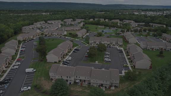 A bird's eye view of a residential area with houses and cars.
