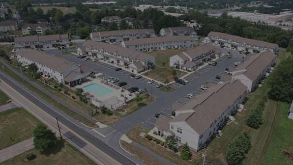 A large apartment complex with a pool in the middle.
