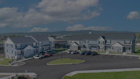A row of houses with trees in front.