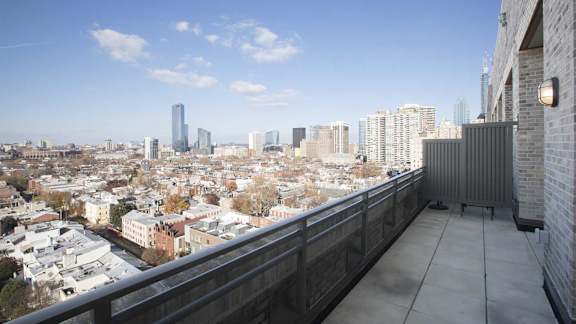 A cityscape with a mix of modern and older buildings is visible from a high vantage point.