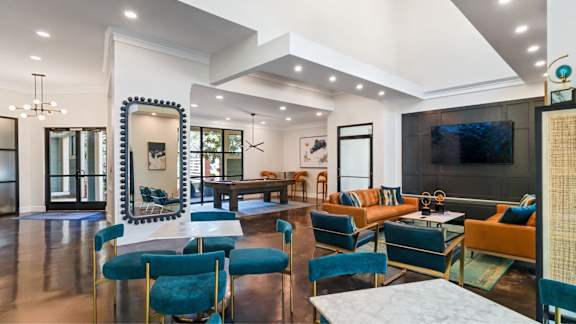A living room with a white sofa and blue chairs.