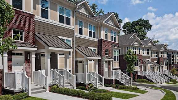 A row of houses with white front doors and steps.