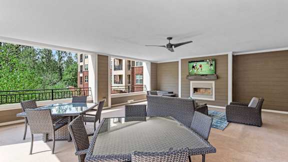 A patio with a table and chairs and a television.
