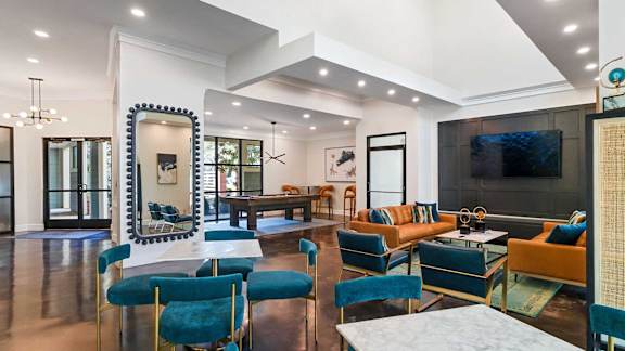 A living room with a white couch and blue chairs.