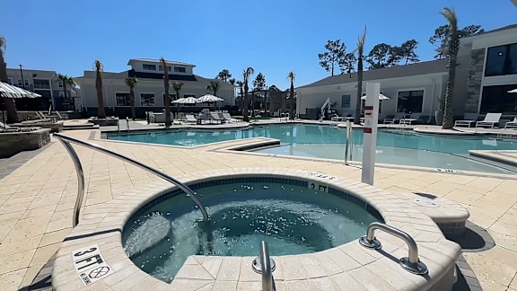A large outdoor swimming pool with a hot tub in the middle.