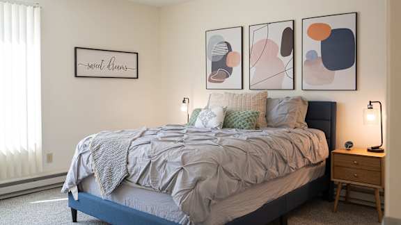 a bedroom with a bed and pictures on the wall