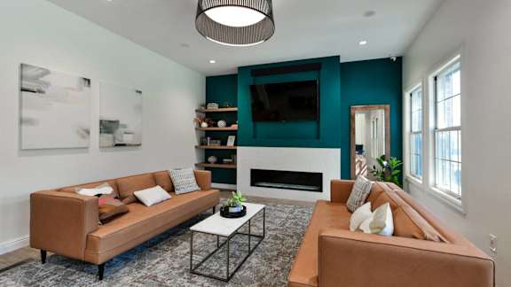 a living room with two brown couches and a television