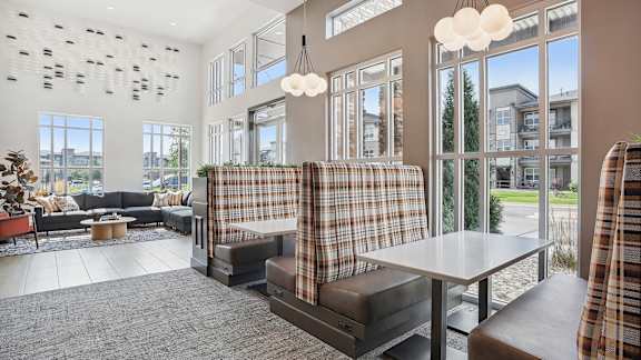 A modern living room with a large window and a plaid couch.