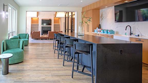 a kitchen with a long counter and a row of stools in front of it
