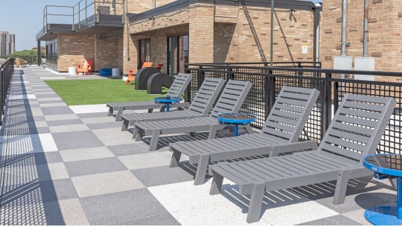 a row of gray lounge chairs with blue trays on top of them
