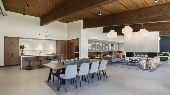 A modern open plan living and dining area with a kitchen in the background at The Bosk Apartment Homes, Minnesota
