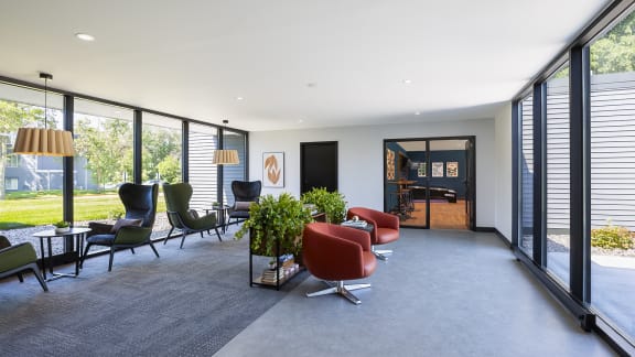a living room with furniture and large windows at The Bosk Apartment Homes, Woodbury, MN, 55125
