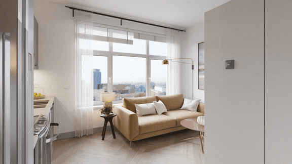 A modern living room with a large window and a beige sofa.