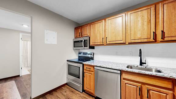 A kitchen with wooden cabinets and a white countertop.
