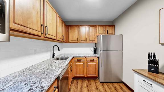 A kitchen with wooden cabinets and a granite countertop.