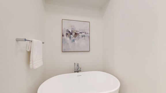 A white toilet with a white towel hanging on the wall.