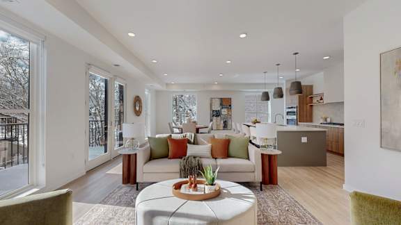 A modern living room with a large window and a view of trees outside.