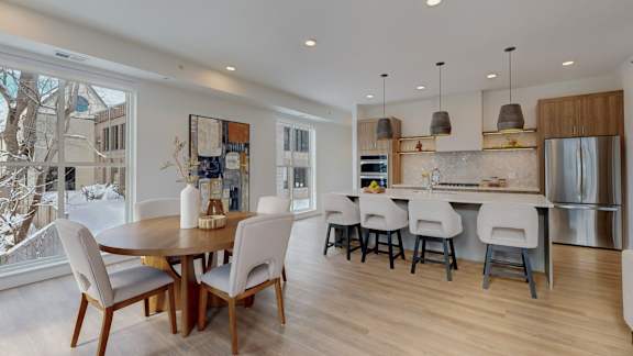 A modern kitchen with a dining table and chairs.