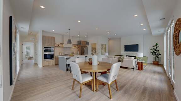 A modern kitchen with a dining table and chairs.