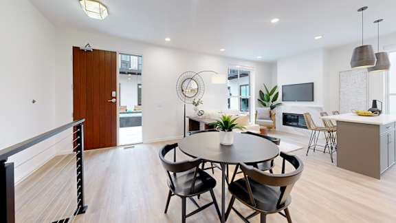 A modern dining room with a round table and chairs.