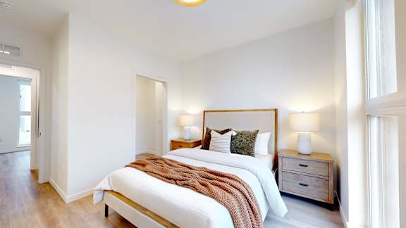 A bedroom with a bed, nightstand, and lamp.